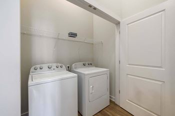 a washer and dryer in a laundry room with white walls and a door